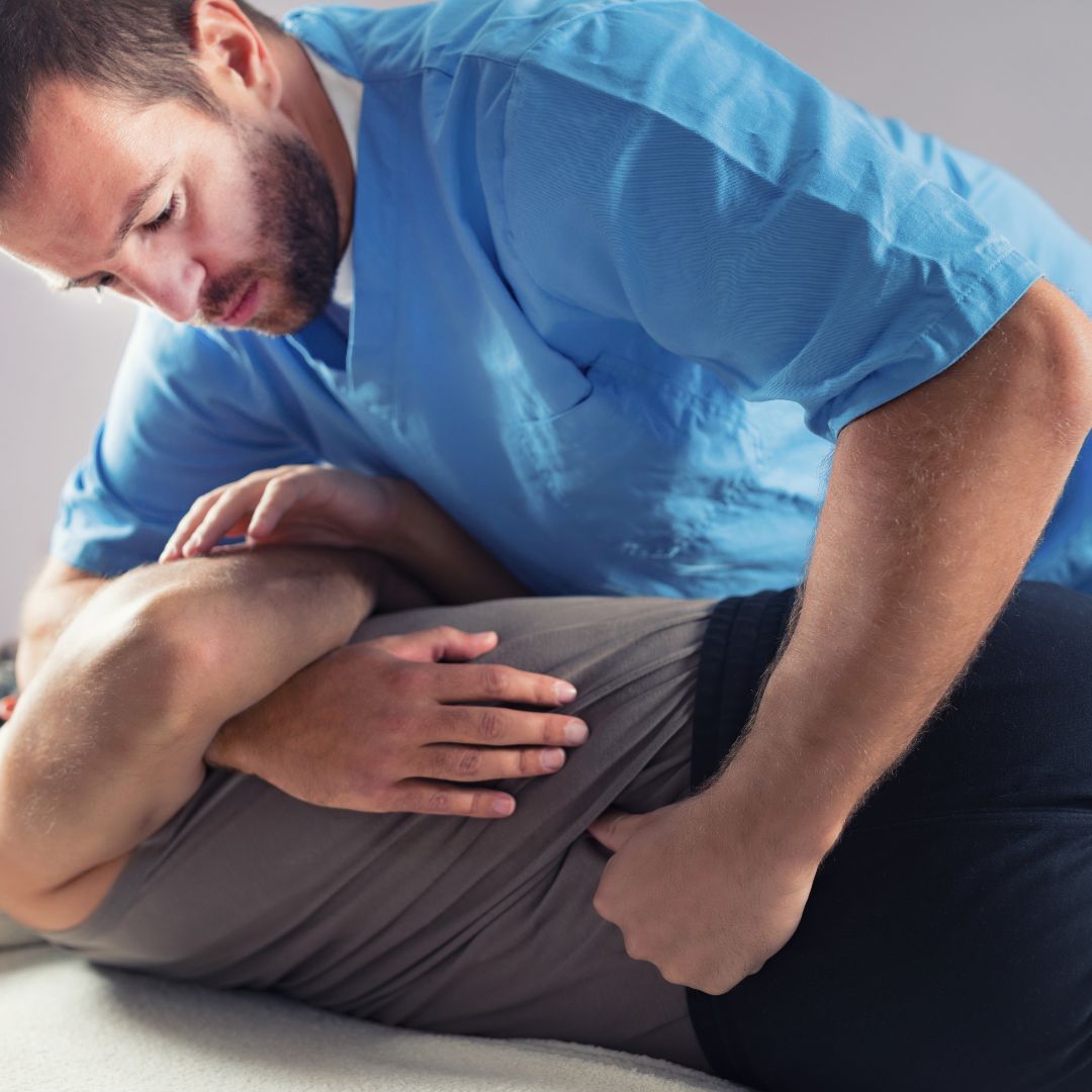 Chiropractor performing a spinal adjustment on a patient lying on their side to improve alignment and relieve discomfort